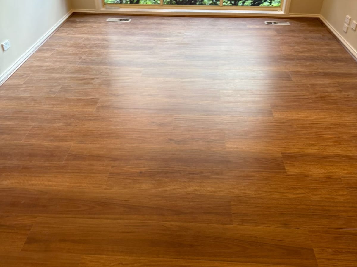 Jarra 1007 hybrid planks in an empty room with a large timber-framed window.